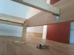 an unfinished room with wood flooring and wooden ladders on the ground next to it