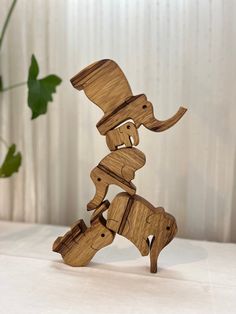 a wooden sculpture of an elephant with a hat on it's head and legs