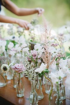 a table topped with lots of vases filled with flowers