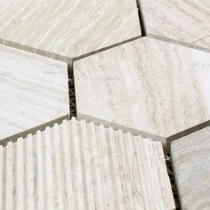 several white marble tiles arranged on top of each other in different sizes and shapes,