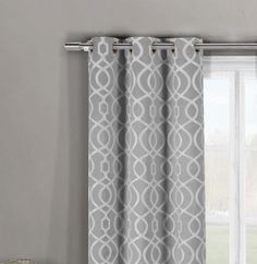 the curtains are hanging in front of a window with grey and white patterns on it