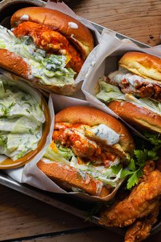 four sandwiches with different toppings sit on a tray