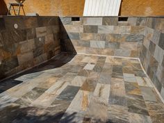 an outdoor area with stone walls and tiled flooring