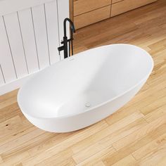 a white bath tub sitting on top of a wooden floor