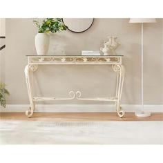 a white console table sitting in front of a wall with a mirror on top of it