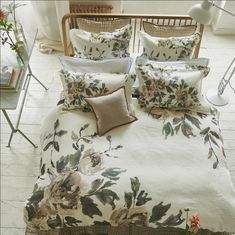 a bed with flowers on it in a room next to a table and chairs,