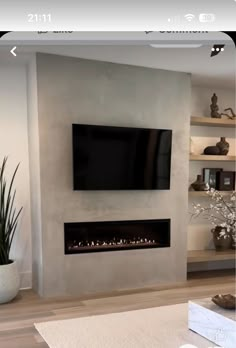 a living room with a large flat screen tv mounted on the wall and a fireplace