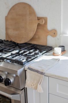 a stove top oven sitting next to a wooden cutting board on the side of a kitchen counter