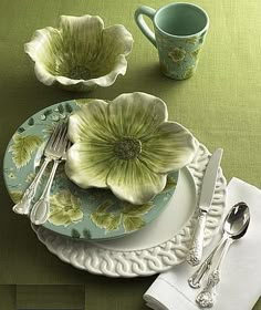 an image of a table setting with flowers on the plate and silver utensils