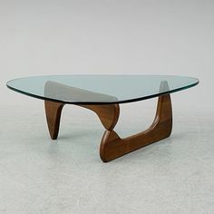 a glass and wood coffee table with curved legs