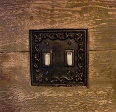 two light switch plates mounted to a wooden wall with metal trimmings on the sides