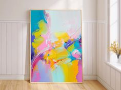 an abstract painting is displayed in the corner of a room with white walls and wooden floors