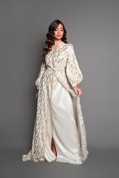 Swan neck caftan and puffed sleeves Colors: ivory subtly tinted with golden nuances The Wiheme caftan embodies timeless elegance with its swan neck and its puffed sleeves which add a touch of romanticism. Made from a light, silky fabric, this kaftan wraps you in absolute comfort. The details of Moroccan sfifa and aqaads bring cultural richness to this creation. A matching belt perfects the silhouette with finesse.  Immerse yourself in the enchanting world of the Wiheme caftan and let yourself be Caftan Simple Chic, Wedding Kaftan, Caftan Simple, Swan Neck, Moroccan Dress, Moroccan Caftan, Silky Fabric, Silky Dress, Kaftan Dress