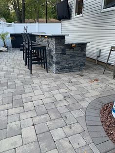 an outdoor kitchen and bar area in a backyard