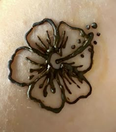 a close up view of a flower on someone's arm with drops of water