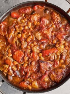 a pan filled with meat and vegetables on top of a stove