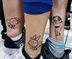 two people with matching tattoos on their legs, one has a cartoon character and the other has