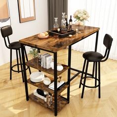 a kitchen table with two stools next to it on top of a hard wood floor