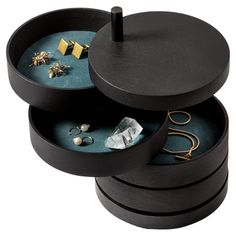 three round black boxes with jewelry in them