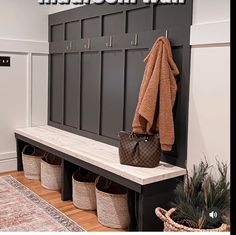 a bench with baskets and a coat rack on it next to a rug in a room