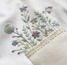 a close up of a white shirt with flowers on the front and back of it