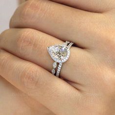 a woman's hand with a diamond ring on top of her finger and an engagement band