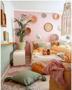 a bedroom with pink walls and lots of pillows on the floor next to a bed