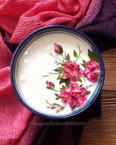 a bowl filled with yogurt and pink flowers