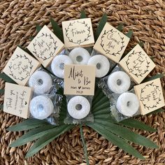 a bunch of white candles sitting on top of a wicker basket next to each other