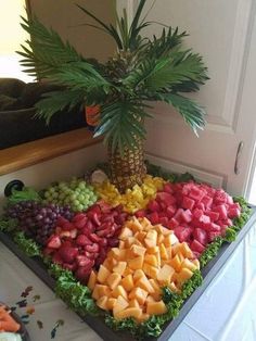 a palm tree sitting on top of a table filled with fruit