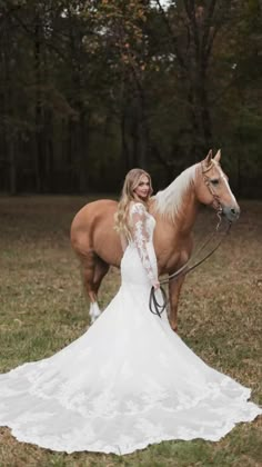 a woman in a white dress standing next to a brown horse wearing a bridal gown