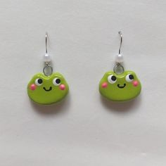 pair of green earrings with pink eyes on white background