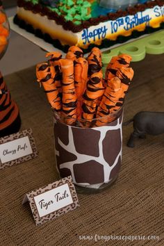 there are carrots wrapped in zebra print and placed in a cup on the table