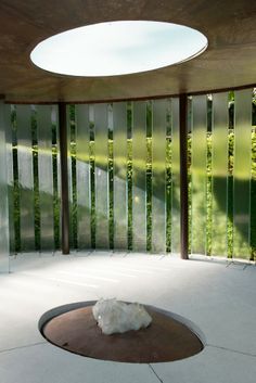 a white object sitting on top of a floor next to a glass window covered wall