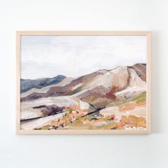 a painting hanging on the wall with mountains in the background