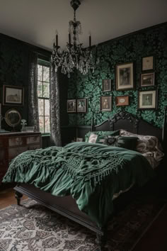 a bed in a room with green wallpaper and pictures on the walls above it