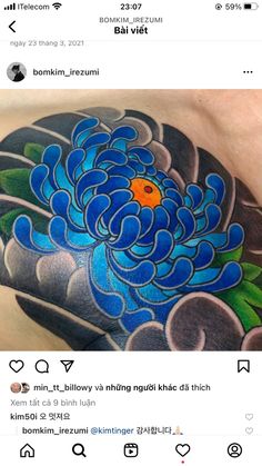 an image of a tattoo on someone's chest with blue and green flowers in the middle