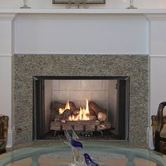 a living room with a fire place and glass table