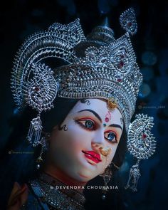 a close up of a statue of a woman wearing a tiara and jewelry on her head