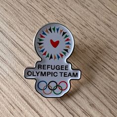 a pin with the olympic logo on it