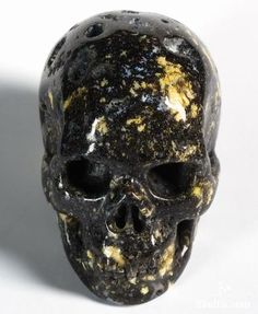 a black and gold skull is shown against a white background with only one eye visible