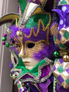 a mardi gras mask with purple and green decorations