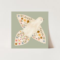 a card with a white bird on it's wings and flowers around its body