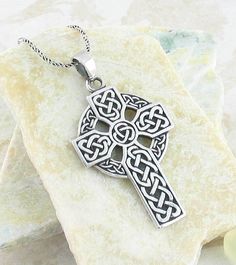 a celtic cross pendant on a rock