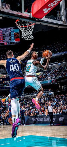 two men playing basketball in front of an audience