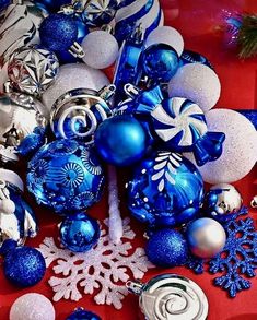 blue and white christmas ornaments on a red table cloth with snowflakes, baubles, ornaments