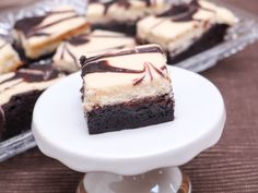 chocolate and white cheesecakes on a cake plate