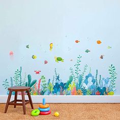 a child's room with an ocean scene wall decal and toys on the floor