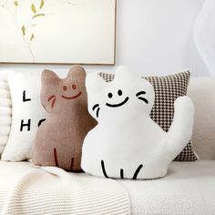 two pillows sitting on top of a couch next to each other in front of a painting