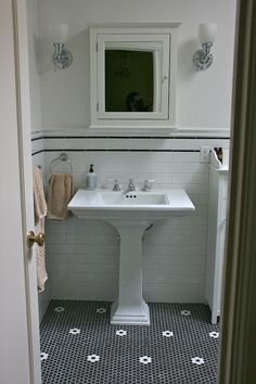 a white sink sitting under a mirror in a bathroom